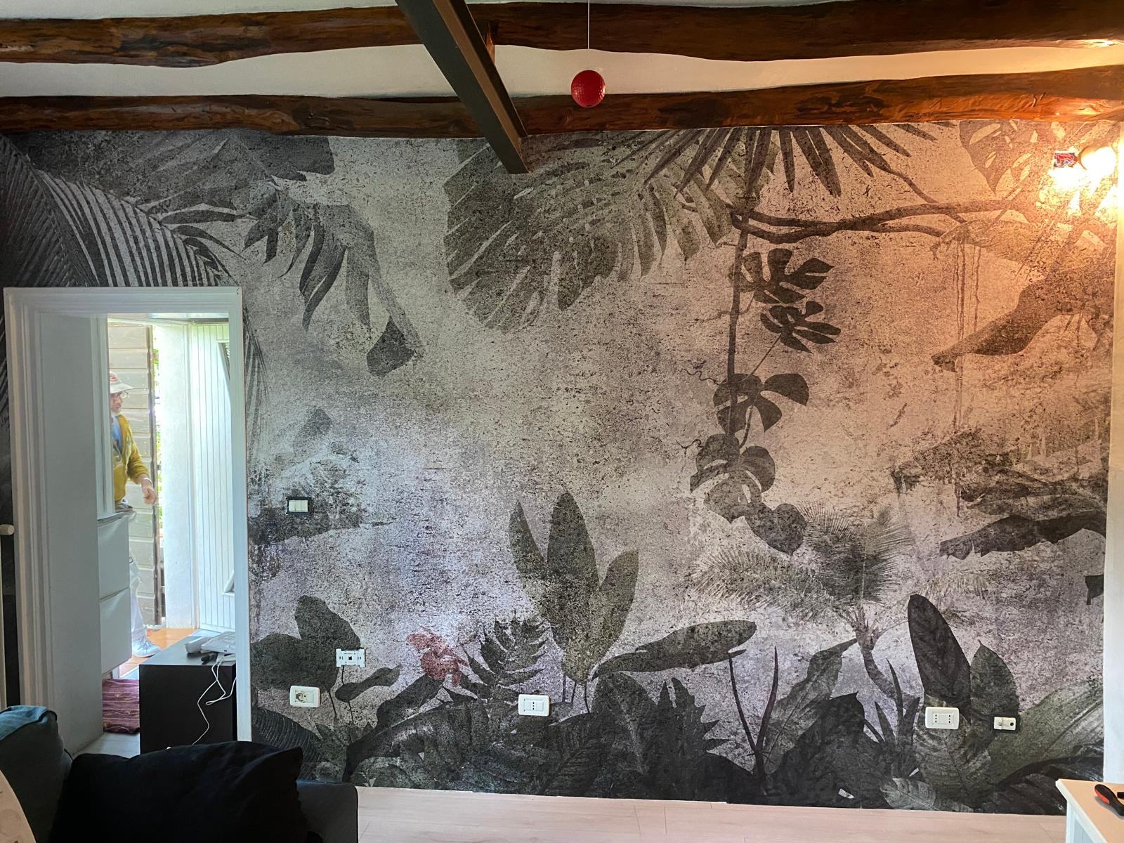 Parete decorativa con motivi tropicali e texture materica.