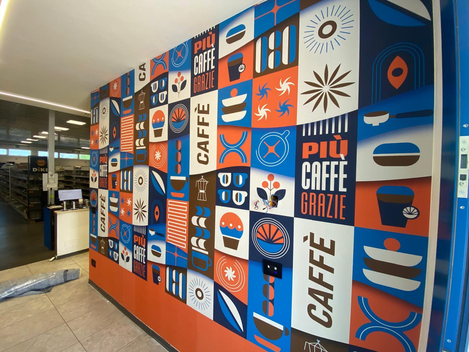 Parete grafica colorata con pattern dedicato al caffè in uno spazio commerciale.